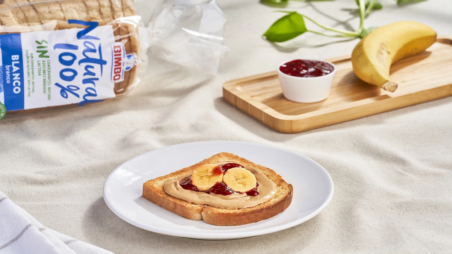 Sándwich de crema de mantequilla de anacardos, plátano a rodajas y salsa de frambuesa