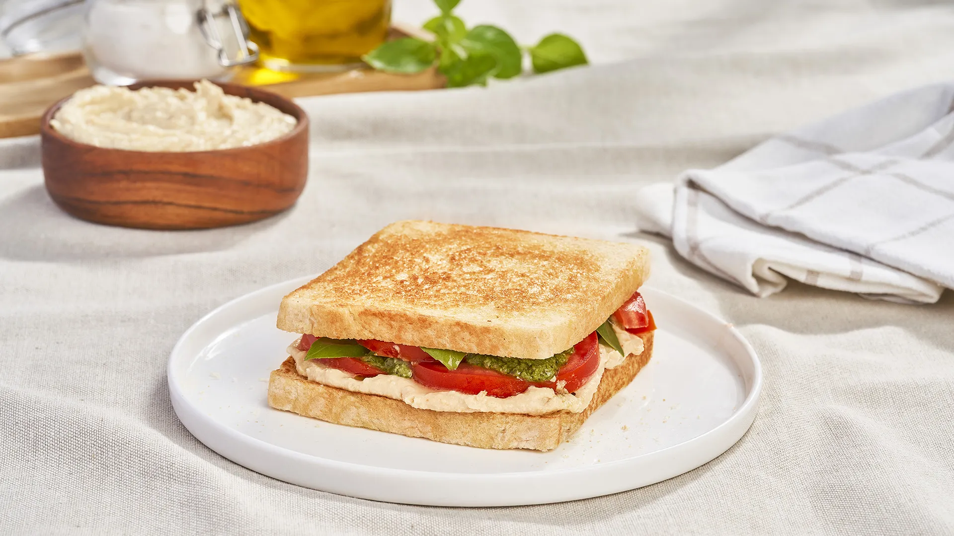Sándwich con hummus, tomate y pesto de albahaca