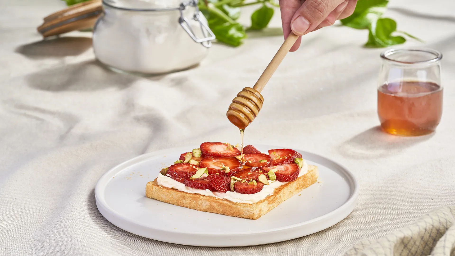 Sándwich con queso crema, fresas, pistachos y miel