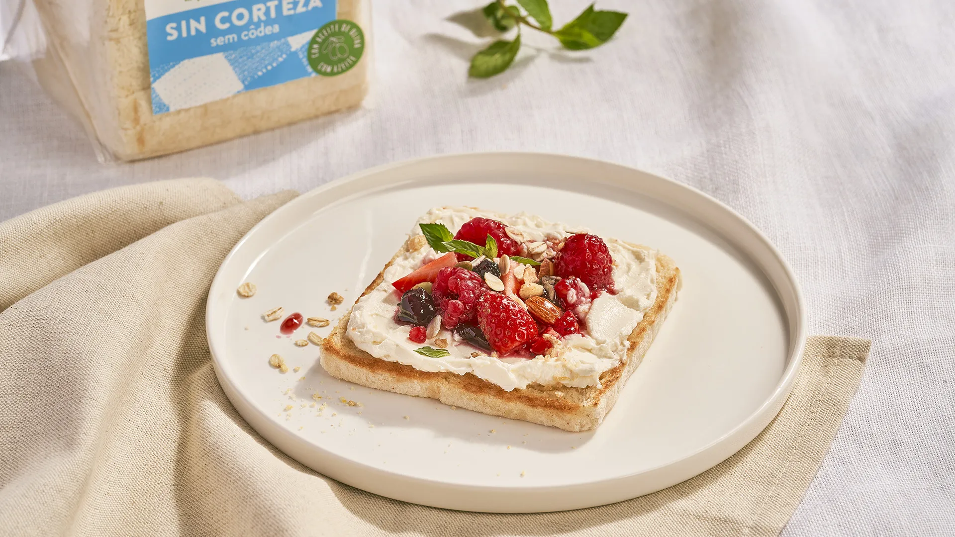Tostada de queso crema, mermelada de frutos rojos y granola