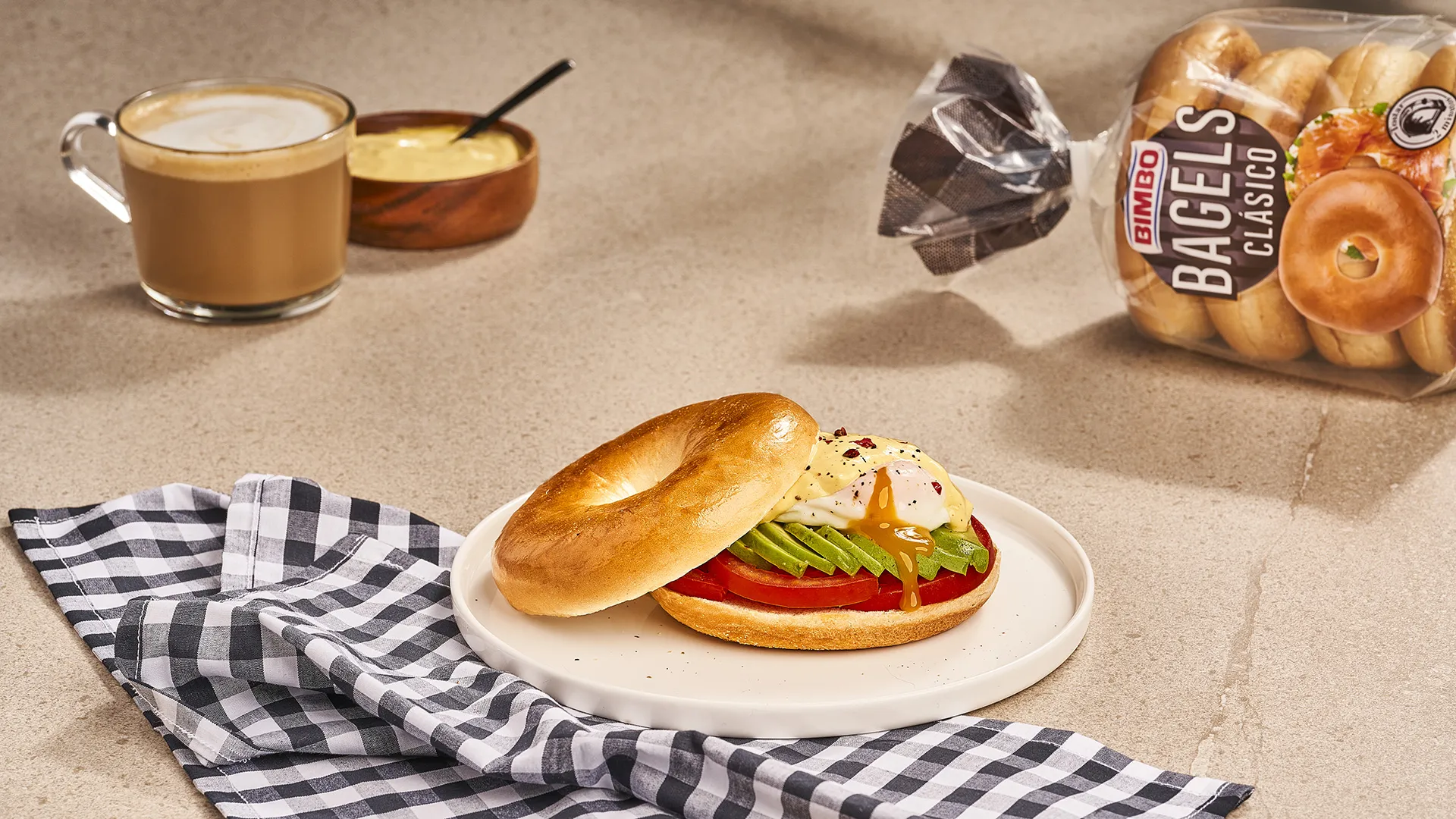 Bagel de aguacate, tomate y huevo poché con salsa holandesa