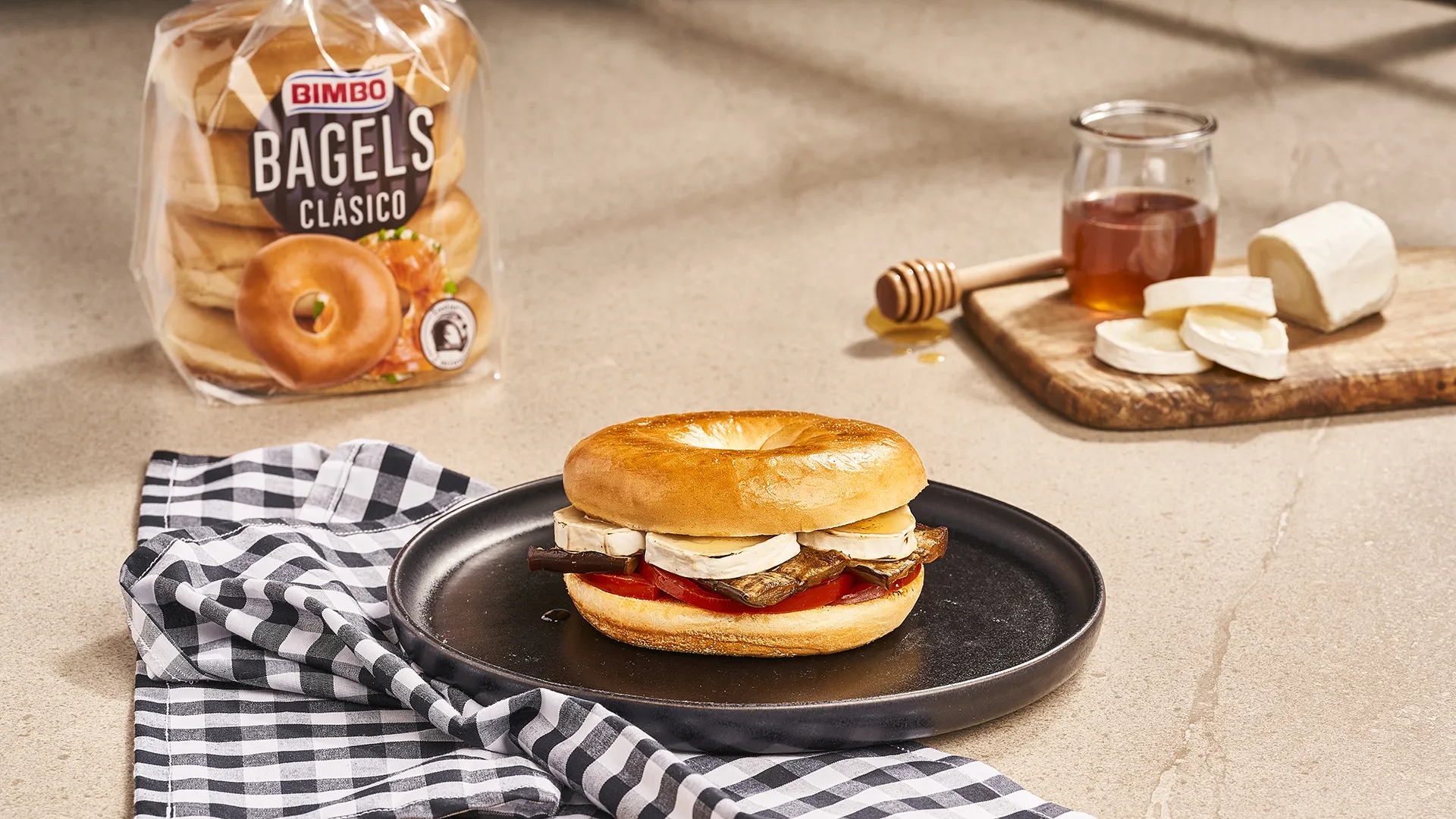 Bagel de berenjena asada, tomate y queso de cabra con miel