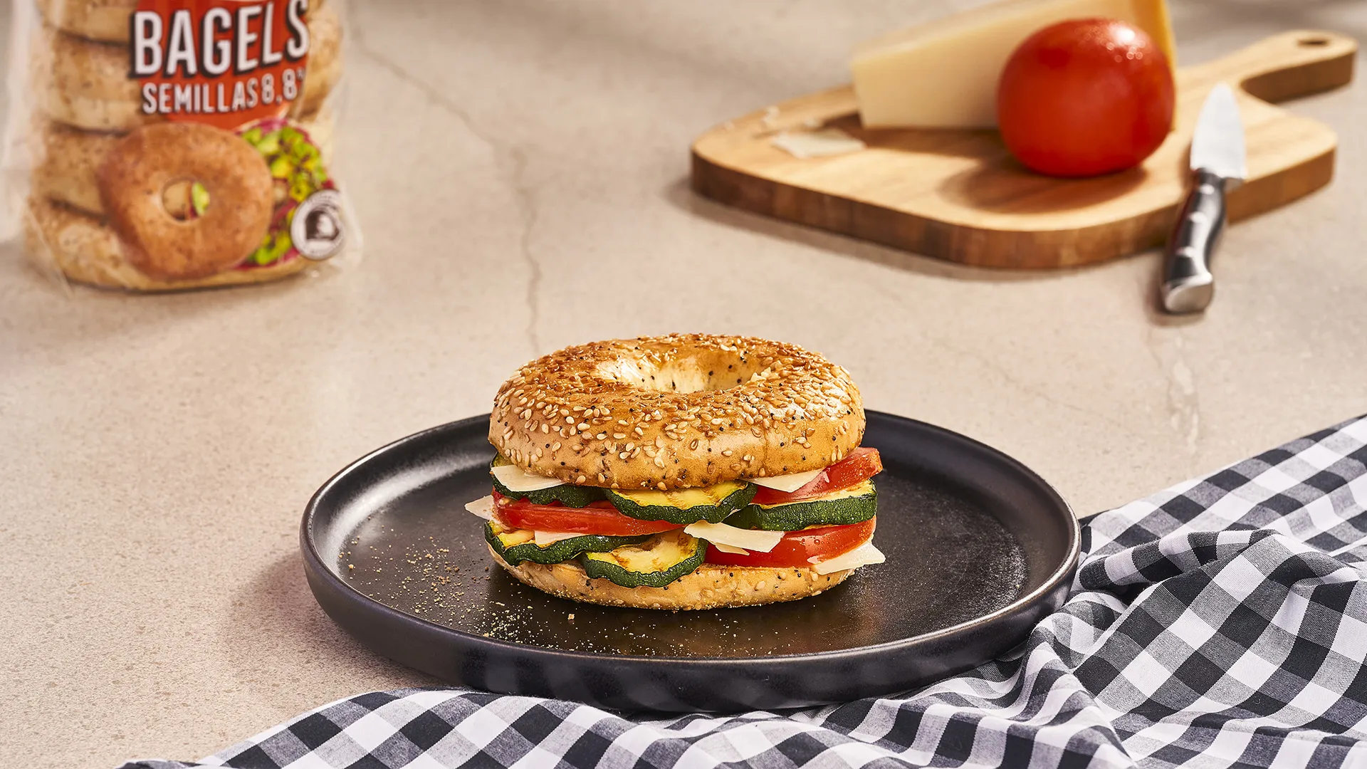 Bagel de calabacín a la plancha, tomate, lascas de queso parmesano y vinagreta