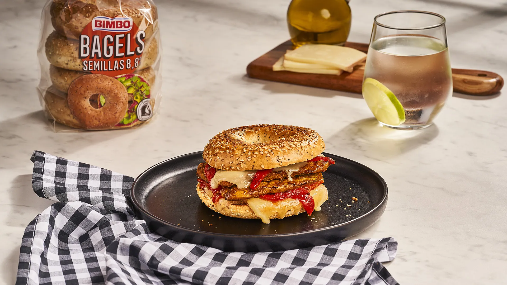 Bagel de pollo marinado, pimientos asados y queso raclette