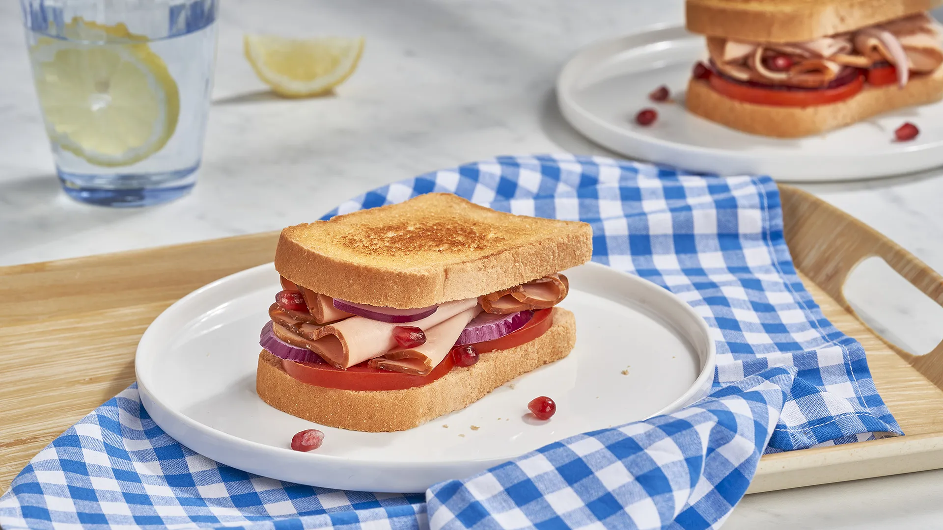 Sándwich de tomate, pavo braseado, cebolla morada y granada