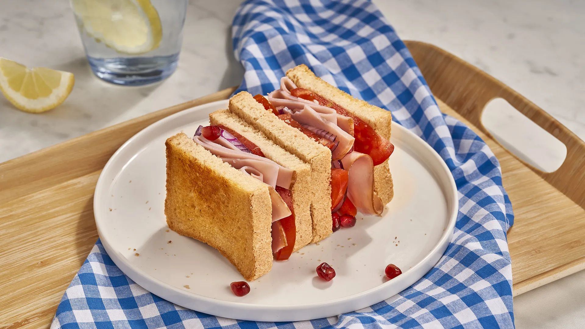 Sándwich de tomate, pavo braseado, cebolla morada y granada
