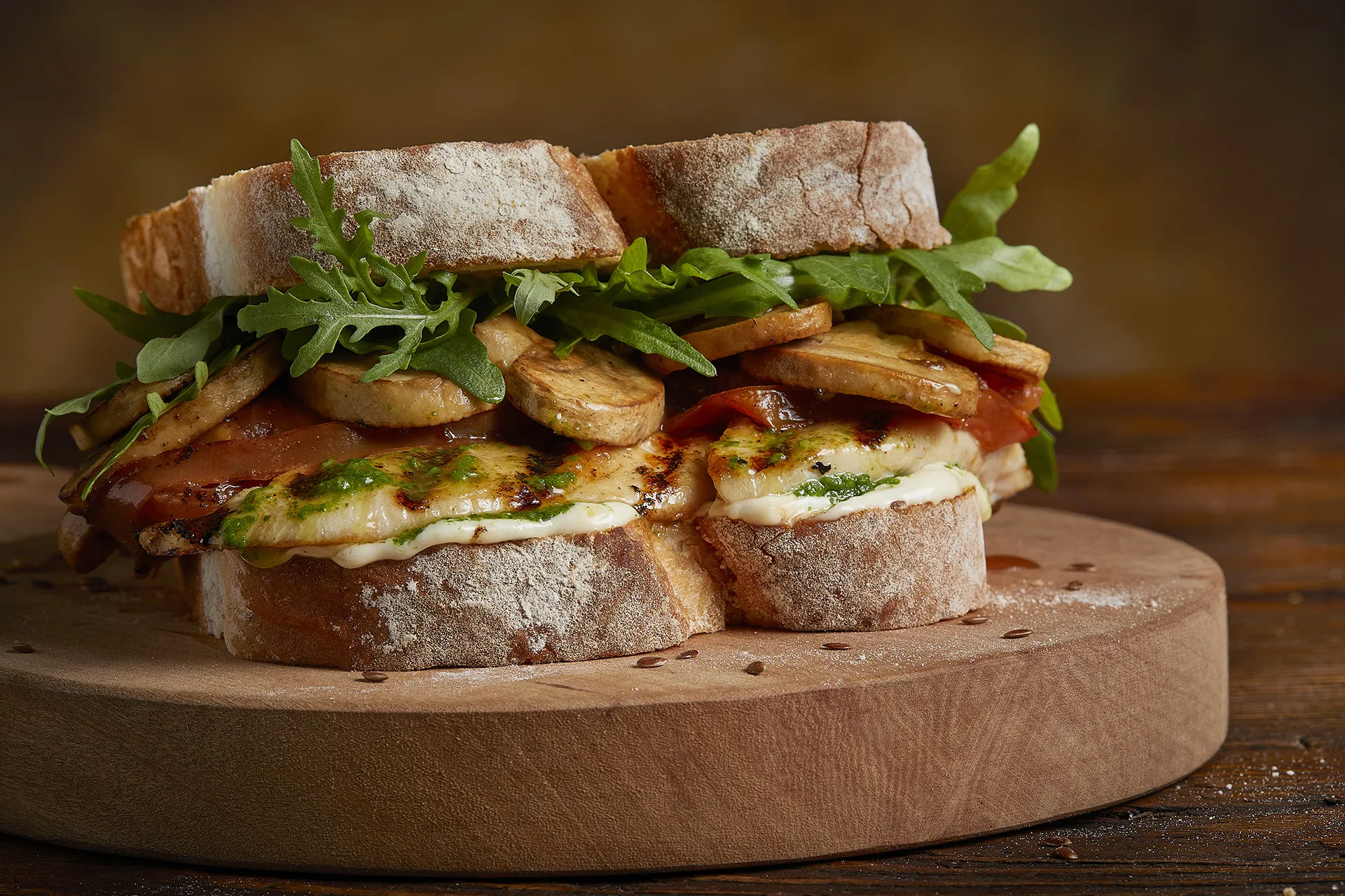 Sándwich de pollo a la parrilla con tomates disecados, champiñones, rúcula y alioli