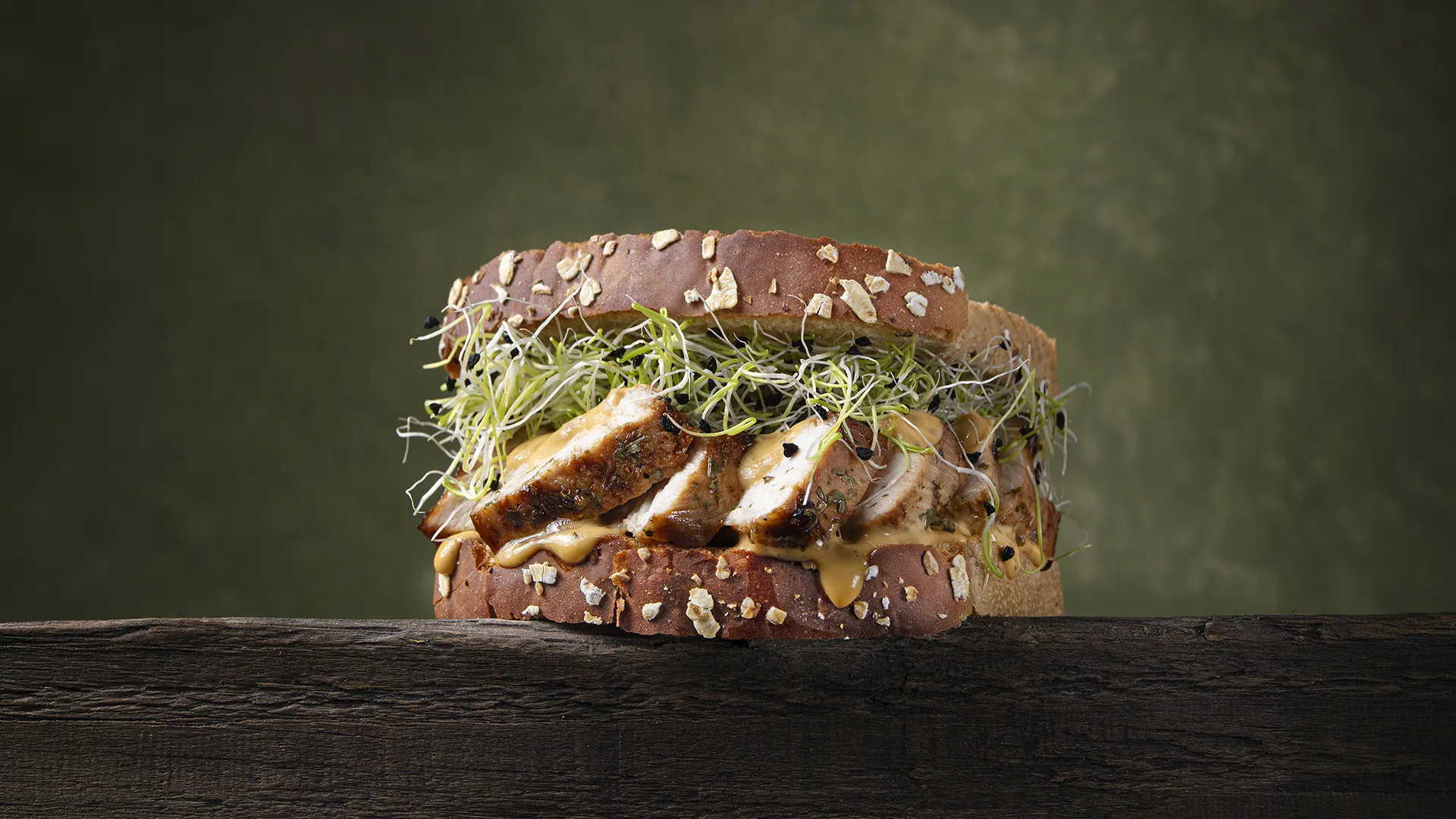 Sándwich de pollo braseado con salsa de mostaza y brotes germinados
