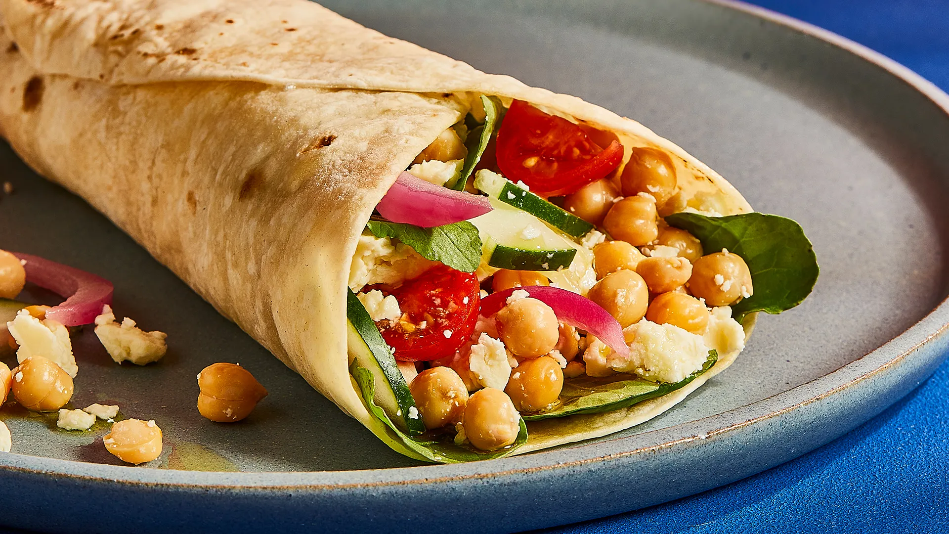 Wrap de queso, pepino, tomate, garbanzos, brotes y cebolla